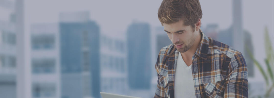 man using IoT device with tall buildings in background